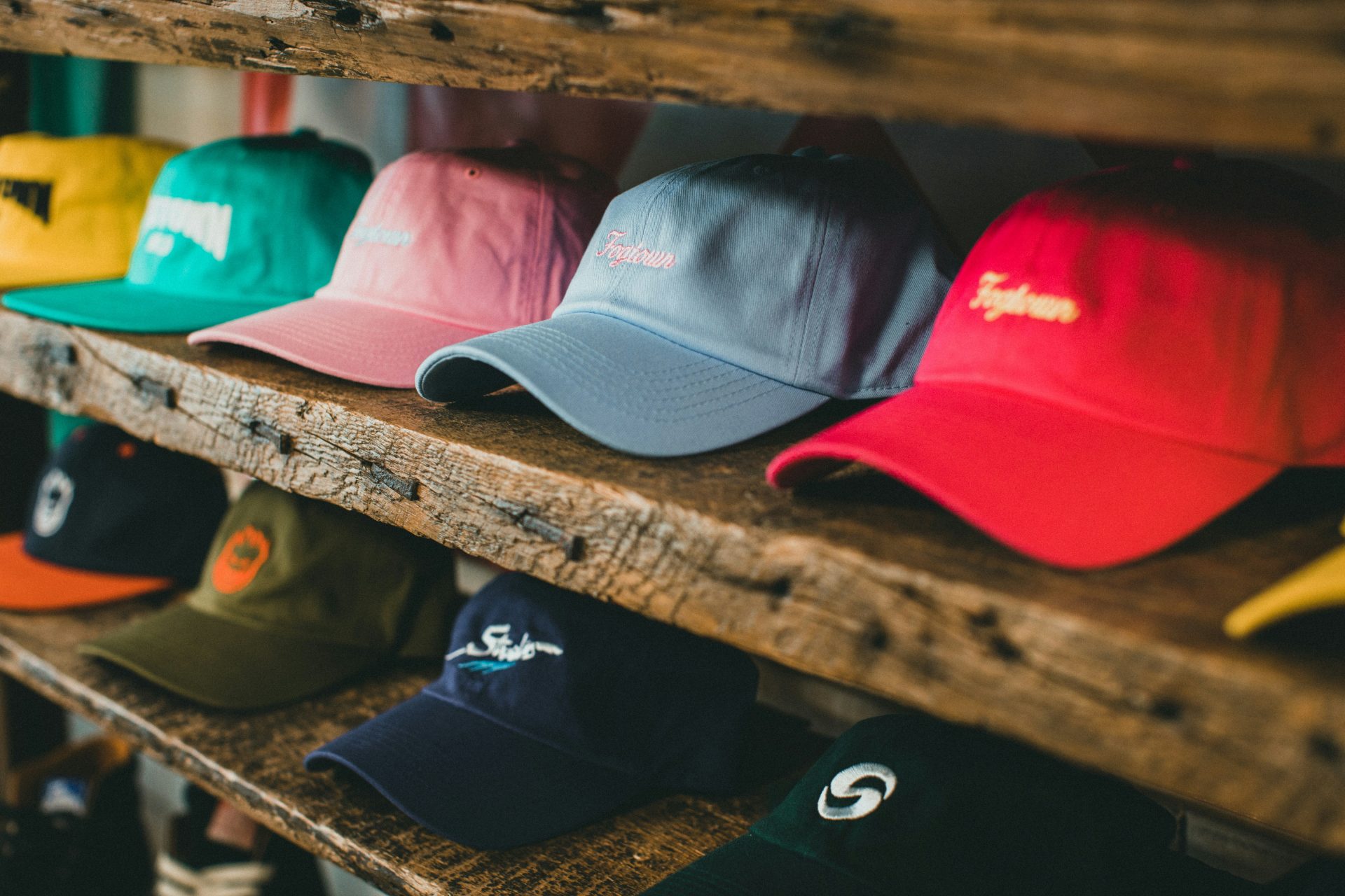 a row of hats sitting on top of a wooden shelf
